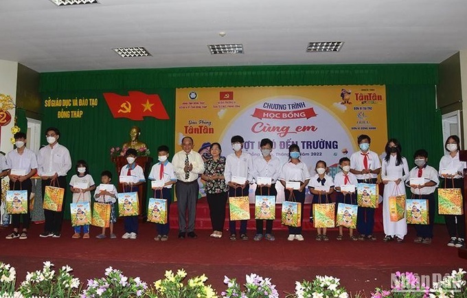 Các đại biểu trao học bổng “Cùng em vượt khó đến trường” cho các em học sinh có hoàn cảnh khó khăn. Ảnh: Báo Nhân dân