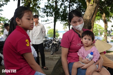 Mẹ bế con giữa phố, cha âm thầm hướng mắt về phía cổng trường thi