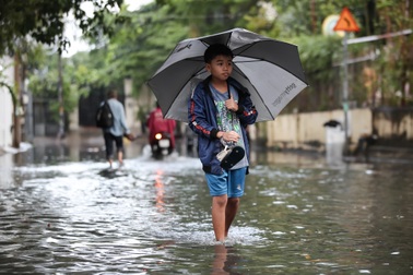 Người dân, du khách bì bõm lội nước sau cơn mưa lớn ở TPHCM