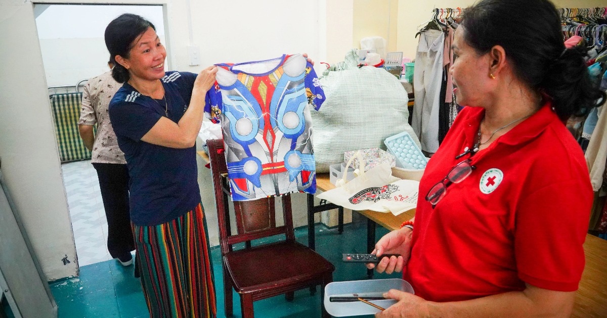 Người lao động nghèo lựa quần áo 0 đồng ở cửa hàng (Ảnh: Nguyễn Vy).