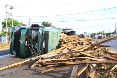 Xe tải chở gỗ lật nghiêng giữa đường sau va chạm