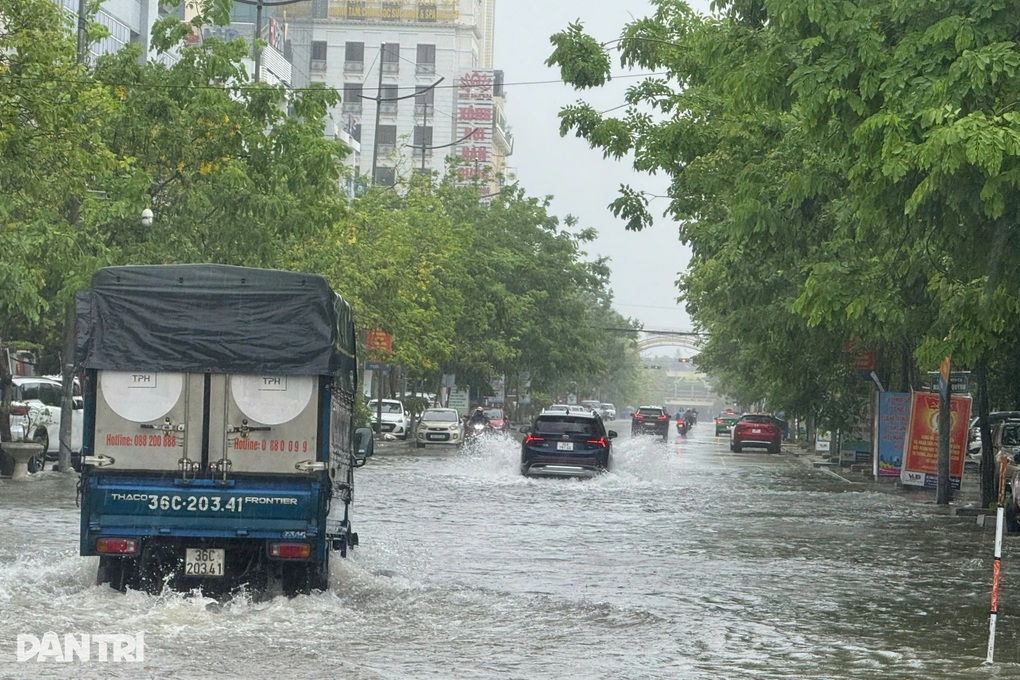 Cảnh sát dầm mưa giúp người dân đẩy xe qua đoạn đường ngập nước - 1 Cảnh sát dầm mưa giúp người dân đẩy xe qua đoạn đường ngập nước - 1