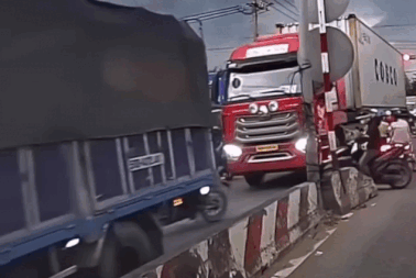 Người đàn ông đi xe máy liều mạng luồn lách cắt ngang đầu xe container