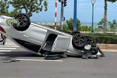 Chiếc xe con lao vào dải phân cách rồi lật ngửa trên đường