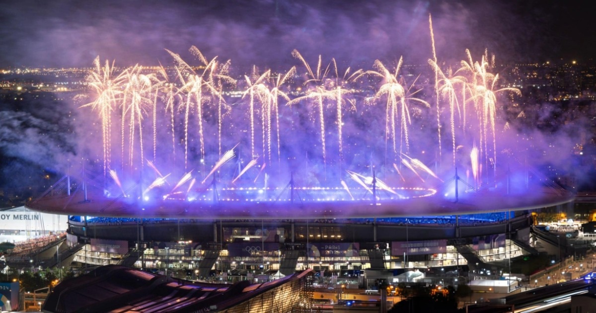 Thị trưởng Paris, Anne Hidalgo, vẫy cờ Olympic trước sự chứng kiến của Tony Estanguet, Chủ tịch Ủy ban tổ chức Thế vận hội Olympic và Paralympic, Chủ tịch IOC Thomas Bach và Thị trưởng Los Angeles, Karen Bass (từ trái sang phải).