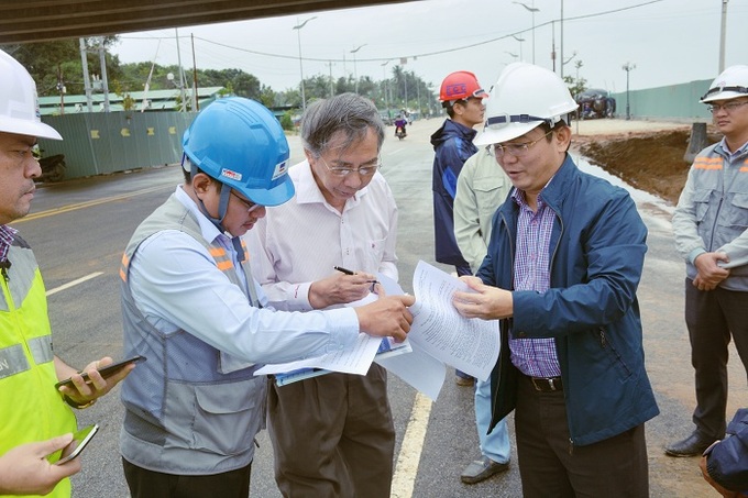 Ông Hà Hoàng Việt Phương (áo xanh-mũ trắng)cùng các kỹ sư trao đổi với các nhà báo về quá trình thi công cầu Cửa Đại. 