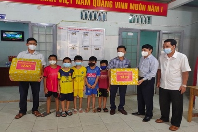 Ông Phạm Minh Tấn - Phó Bí thư Thường trực Tỉnh ủy (thứ 2 bên phải) tặng quà tượng trưng cho các em