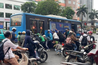 Hơn chục người nâng xe buýt để cứu nữ tài xế xe máy mắc kẹt dưới gầm