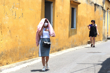 Du khách đội mũ rộng vành, xịt kem chống nắng để dạo phố ở Hội An