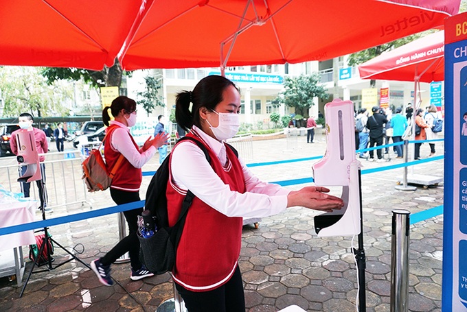 Sát khuẩn tay và đo thân nhiệt trước khi vào lớp. Ảnh hanoi.gov.vn