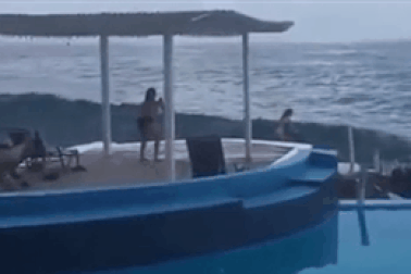 Mải chụp ảnh, cô gái bị sóng lớn cuốn phăng