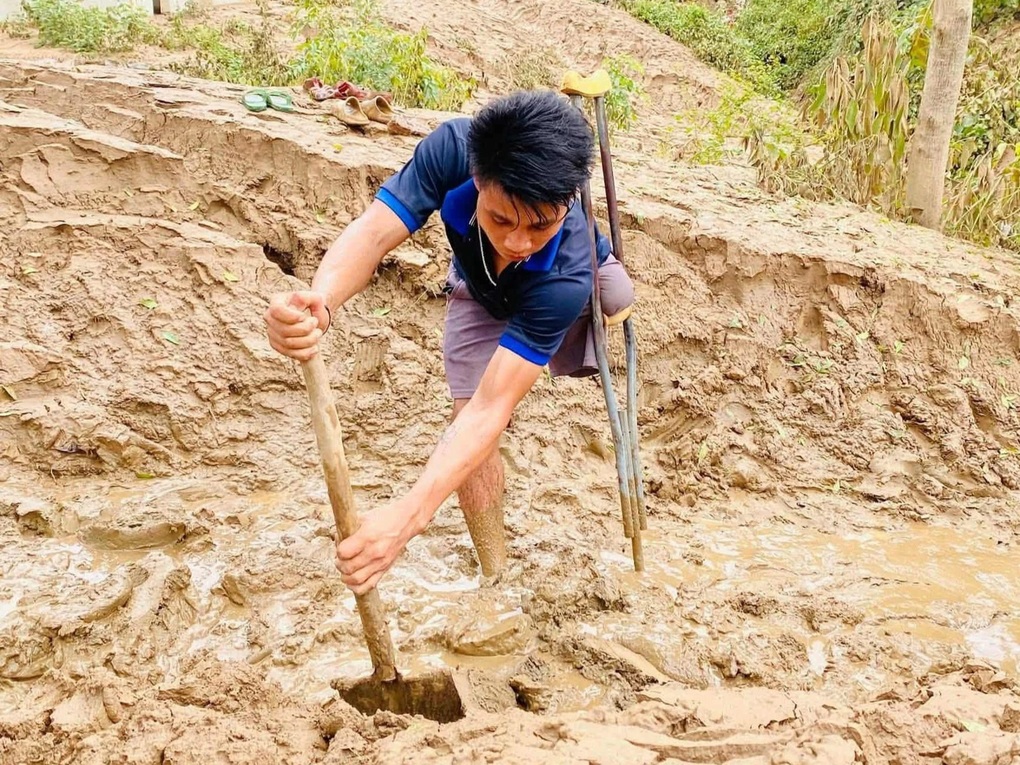 Người đàn ông cụt chân vác xẻng đào bùn giúp hàng xóm sau mưa lũ - 2 Người đàn ông cụt chân vác xẻng đào bùn giúp hàng xóm sau mưa lũ - 2