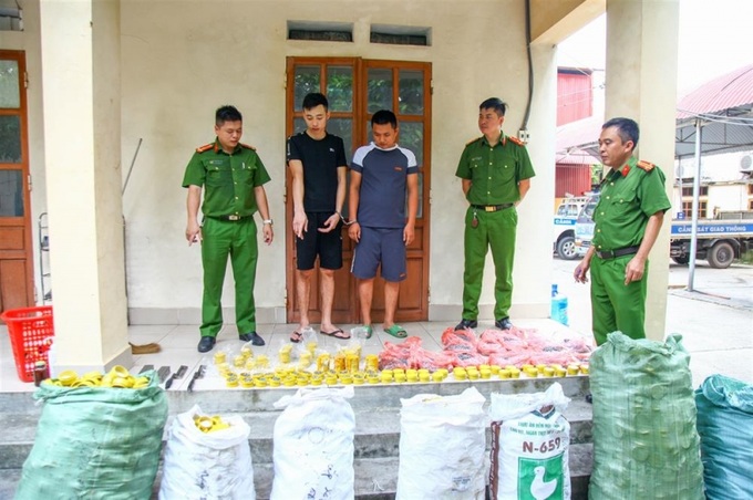 Đối tượng Hải (áo đen) và Hảo (áo xám) cùng số đạn chì tự sản xuất.