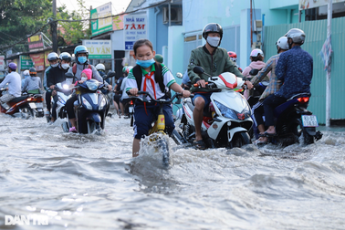 Người dân TPHCM chật vật đến nơi làm việc vì triều cường gây ngập