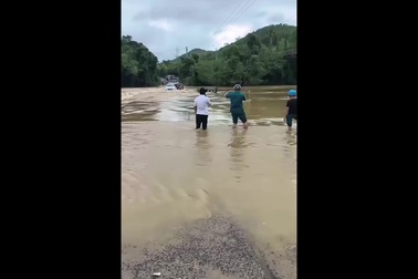 Liều lĩnh chạy xe qua đập tràn, xe sang bị nước lũ cuốn trôi