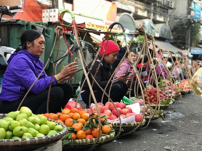 Hàng rong chợ Đồng Xuân vừa bán hàng vừa tranh thủ lên đồ cổ vũ U22 Việt Nam - Ảnh 4.