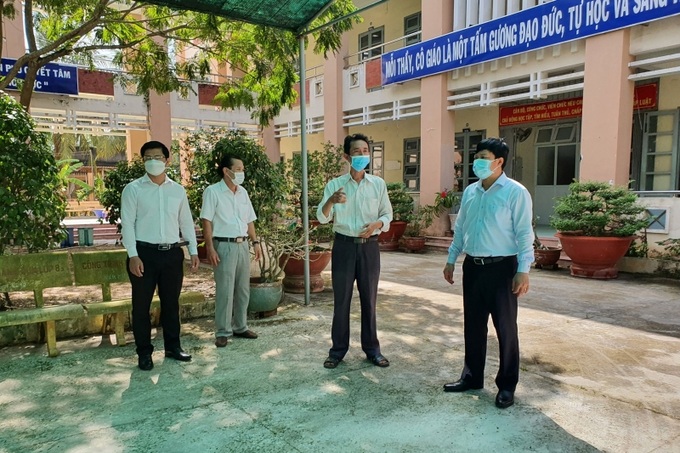 Lê Quang Trí (bên phải) kiểm tra công tác an toàn phòng chống dịch tại huyện Tân Phú Đông trước khi học sinh trở lại trường.
