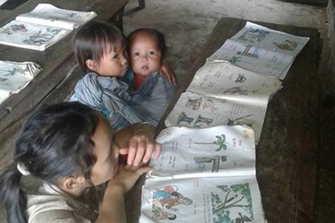 Hình ảnh bé lớp 2 địu em 8 tháng tới trường lay động dân mạng