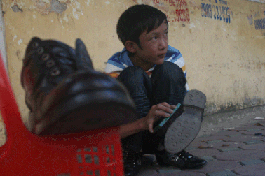 Em bé đánh giày lại dệt ước mơ trên hè phố