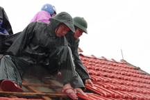 Bộ đội dầm mình dưới cơn mưa xối xả giúp dân sửa nhà sau bão