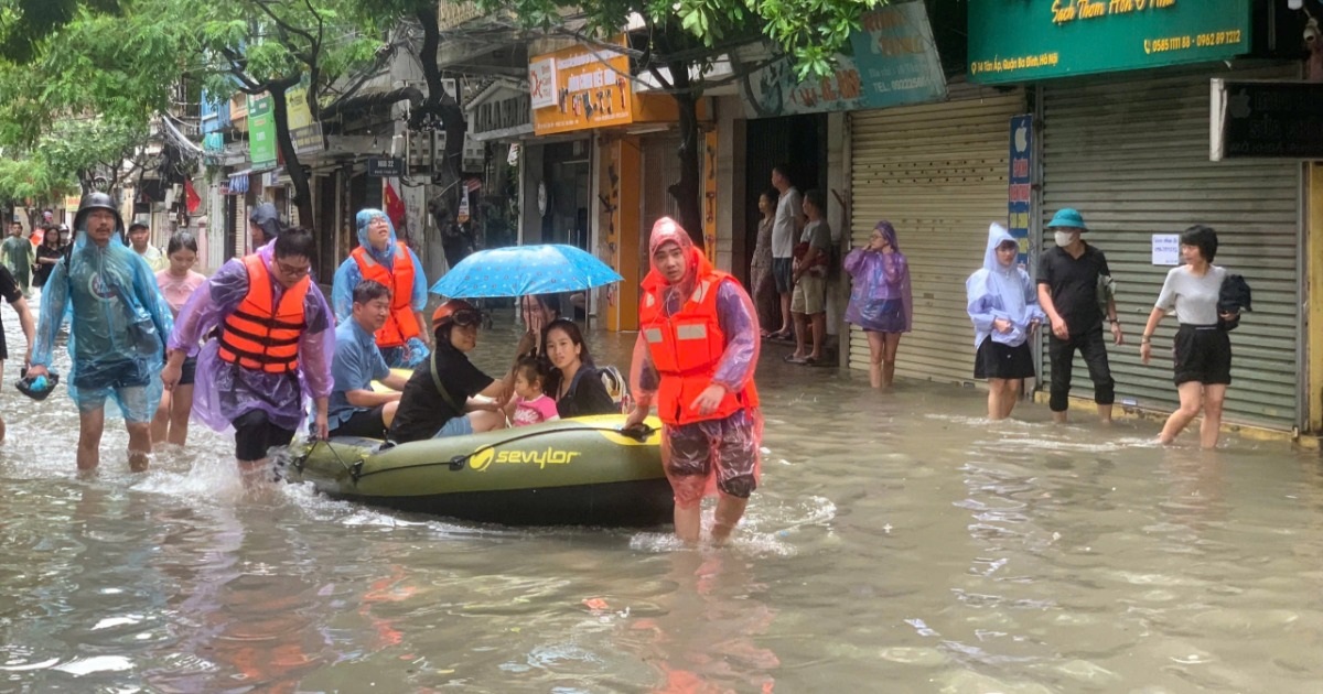 Cán bộ, đoàn viên thanh niên quận Ba Đình hỗ trợ di chuyển cả vật nuôi, đồ đạc của người dân ra khỏi khu vực ngập nước.