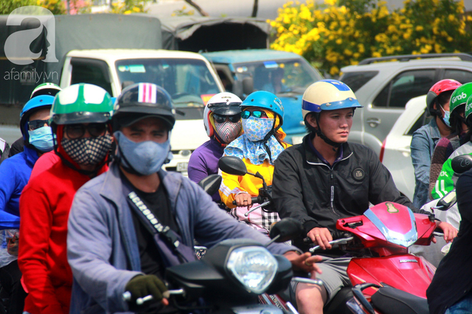 Sài Gòn nắng kinh hoàng sau Tết, người lớn trùm kín như Ninja, trẻ em mệt mỏi gục trên xe - Ảnh 1.