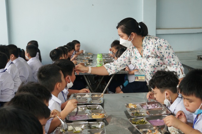 Giáo viên được tăng cường phục vụ bữa ăn bán trú tại trường Tiểu học Bông Sao, quận 8 hồi cuối tháng 2. Ảnh: Mạnh Tùng