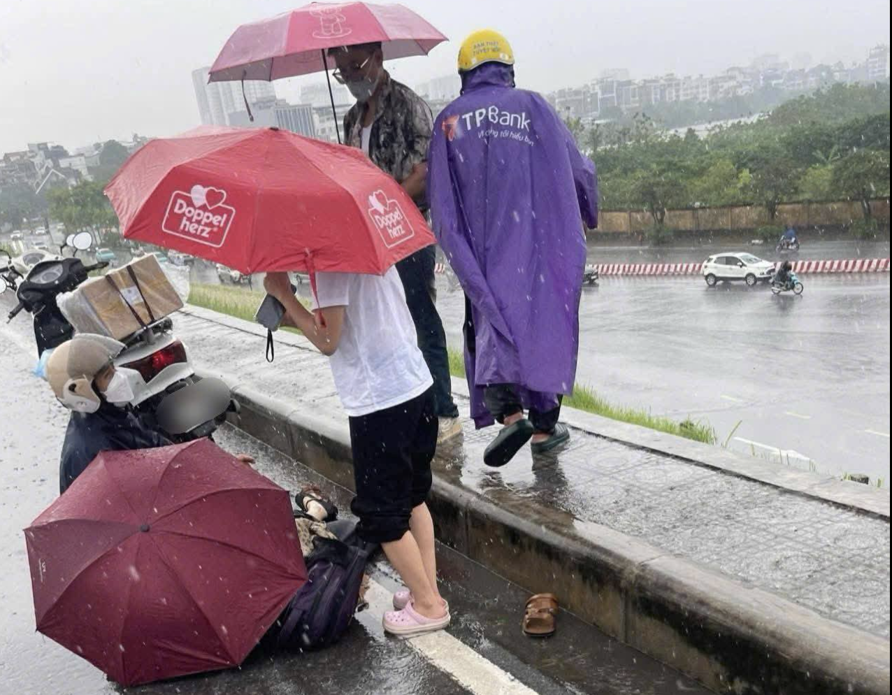 Hà Nội: Đang đi đường, người phụ nữ nghi bị sét đánh trúng nằm bất động - 1