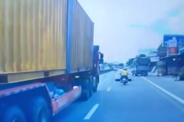 Cặp đôi đi xe máy suýt ngã vào gầm container vì thiếu tập trung