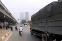 Luồn lách sai làn để vượt, người đi xe máy trượt ngã vào ô tô tải