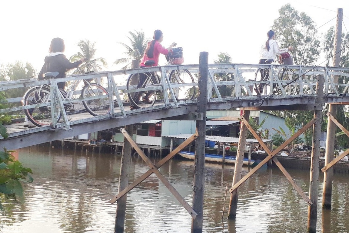 (Dân trí) - Cây cầu ván bắc qua kênh Hương Mai (ấp 5, xã Khánh Hòa, huyện U Minh, tCà Mau) hơn 10 năm qua, giờ đã xuống cấp nghiêm trọng. Mỗi ngày có cả trăm lượt người đi qua lại, trong đó có nhiều em học sinh trong cảnh vừa đi vừa lo sợ trượt chân có thể ngã xuống sông bất kể lúc nào.