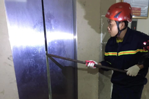 Cảnh sát dùng xà beng cạy thang máy giải cứu 2 người mắc kẹt