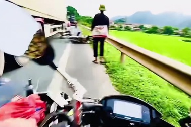 Vượt bất cẩn, người đi xe máy thoát chết đầy may mắn dưới bánh container