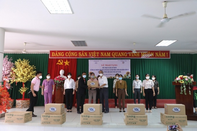 Đại diện Công ty Cổ phần chăn nuôi C.P. Việt Nam trao tặng tượng trưng khẩu trang, nước sát khuẩn cho các trường tại tỉnh Bến Tre.