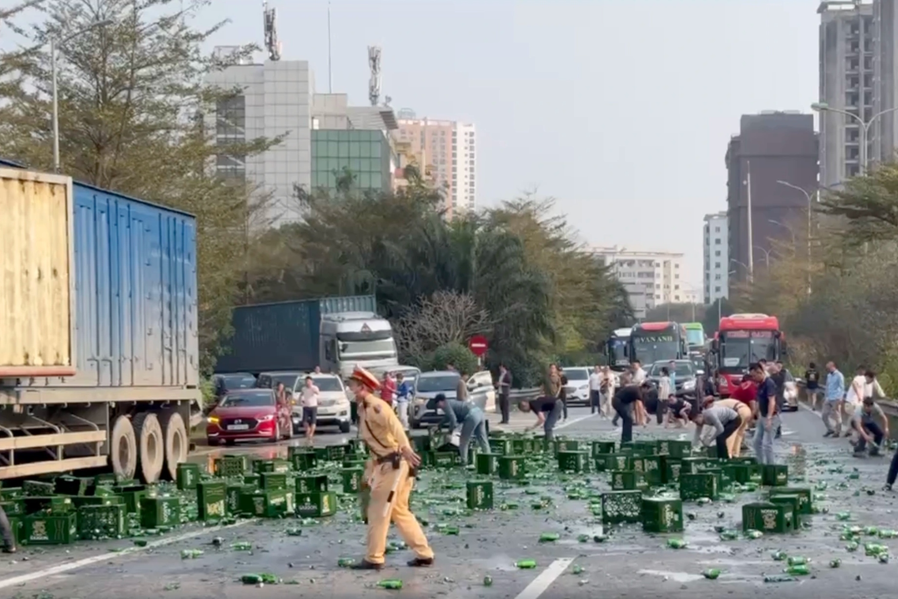 CSGT Hà Nội giúp tài xế container dọn hàng trăm chai bia bị rơi xuống đường - 1