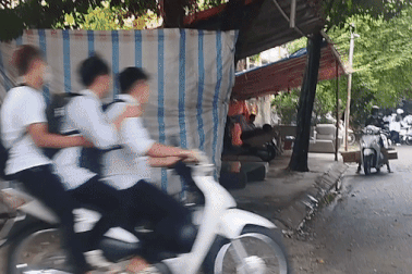 Cảnh học sinh lái xe máy vượt đèn đỏ, kẹp 3, không đội mũ bảo hiểm ở Hà Nội