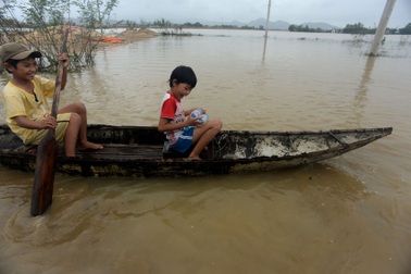 Bị lũ cô lập, trẻ em chèo xuồng đi xin nước sạch