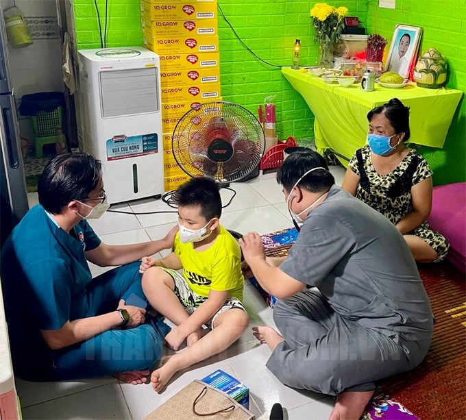 Các bác sĩ trong Hội Thầy thuốc trẻ đang thăm khám sức khỏe cho một bé bị mồ côi tại Bình Chánh.