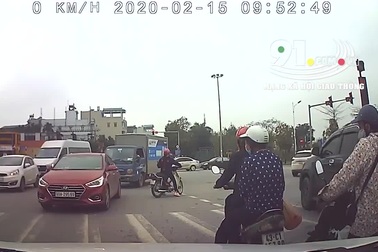 Mặc kệ dòng người qua lại, cô gái thản nhiên dừng xe máy giữa đường