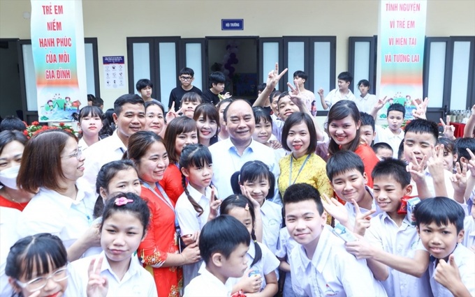 Chủ tịch nước Nguyễn Xuân Phúc chụp ảnh lưu niệm cùng trẻ em tại Trung tâm Nuôi dưỡng trẻ khuyết tật Hà Nội.