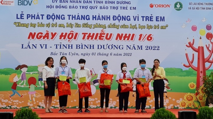 Bà Nguyễn Ngọc Hằng, Phó giám đốc Sở Lao động – Thương binh và Xã hội (bìa phải) cùng nhà tài trợ trao quà cho trẻ em khó khăn.